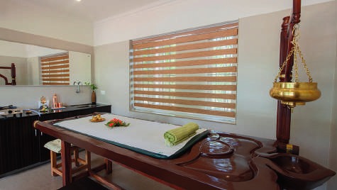 Sala de tratamentos Ayurveda com marquesa e recipiente para óleos