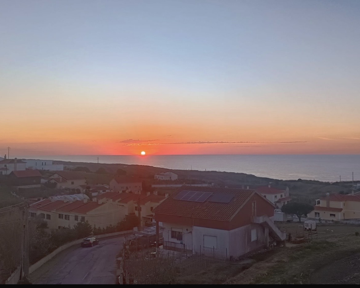 Vista panorâmica do pôr do sol sobre o mar e as casas de Ribamar